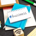 The Ultimate Digital Marketing Guide for Small Businesses in 2026 blue copybook with note colorful pencils dark surface